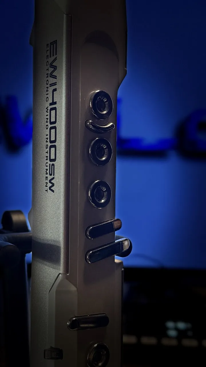 Close-up of an EWI on its stand in blue studio light.