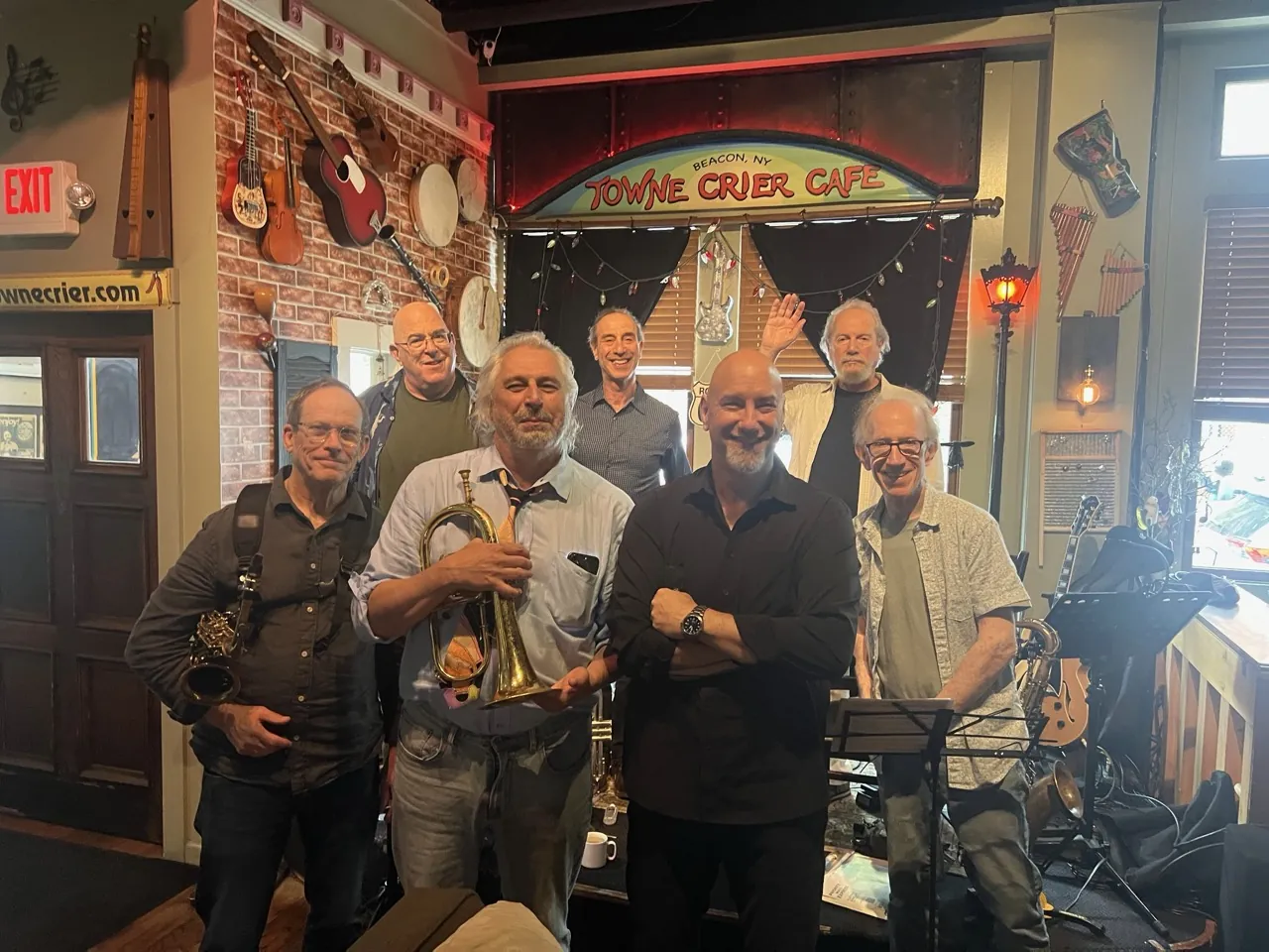 John and his bandmates posing in front of a Towne Crier Cafe stage.