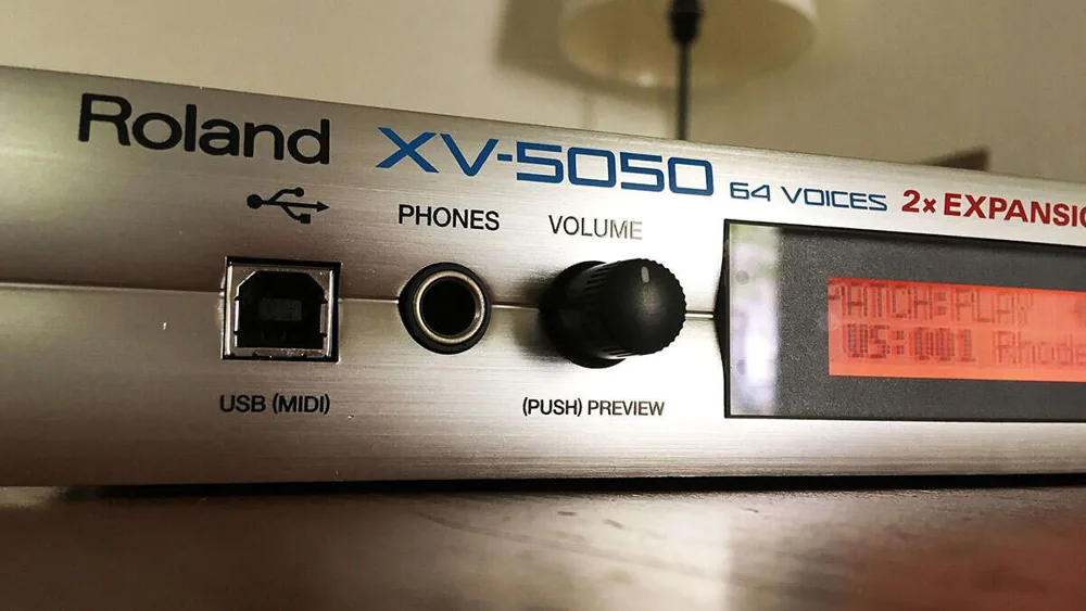 Close-up of the Roland XV-5050 front panel with its USB port, headphone jack, volume knob and display.